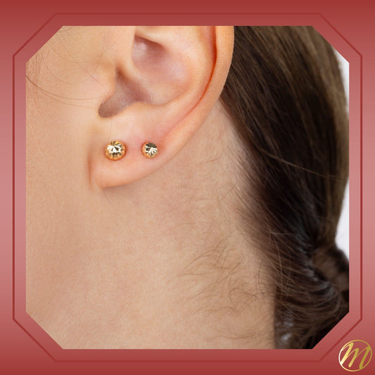 Model wearing 14k yellow gold fluted half ball stud earrings by Massete, view 2