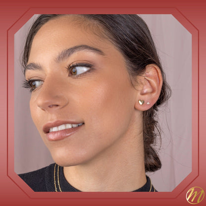 Model wearing 14k yellow gold puff heart stud earrings by Massete, view 6