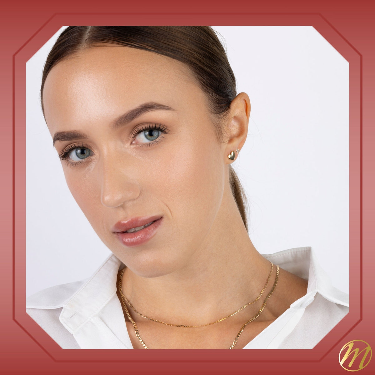 Model wearing 14k yellow gold puff heart stud earrings by Massete, view 5