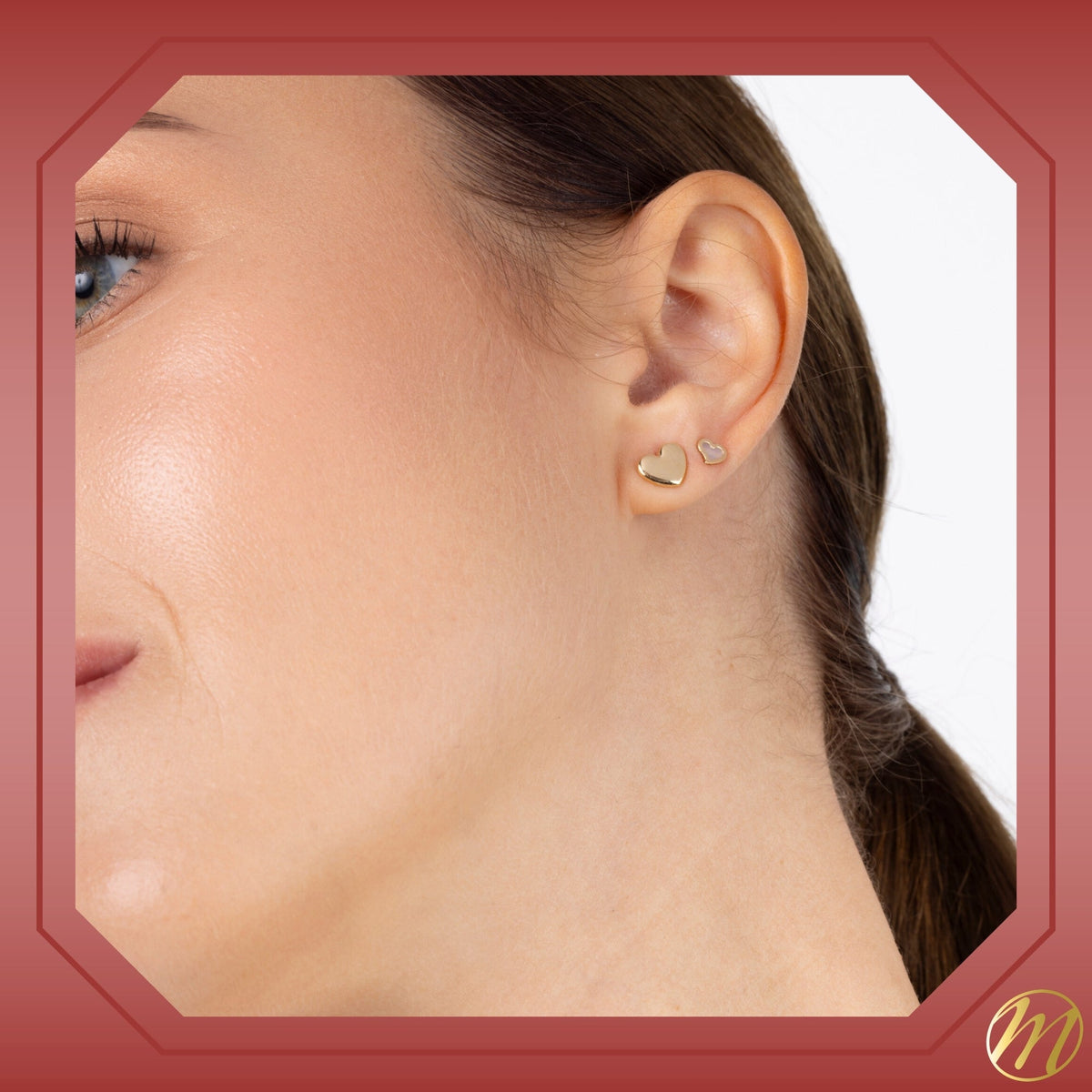 Model wearing 14k yellow gold puff heart stud earrings by Massete