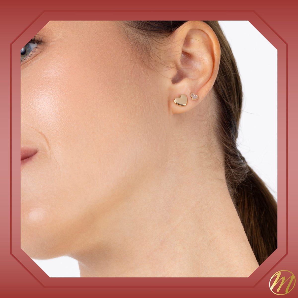 Model wearing 14k yellow gold heart twist stud earrings with mother of pearl by Massete, view 2