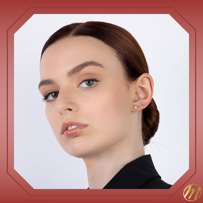 Model wearing 14k yellow gold beaded heart outline stud earrings with pave simulated stones by Massete, view 4