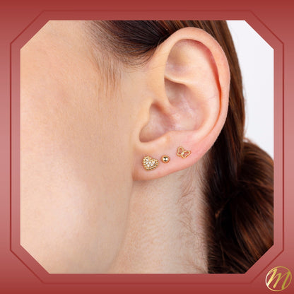 Model wearing 14k yellow gold beaded heart outline stud earrings with pave simulated stones by Massete, view 2
