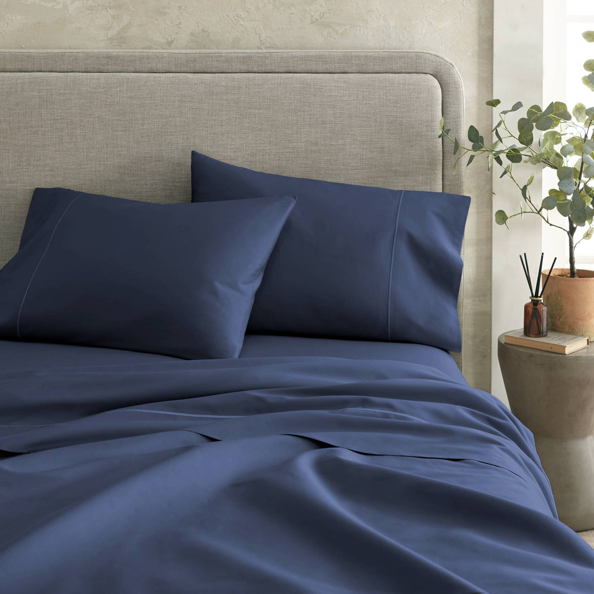Foot-of-bed view of Whisper Organics 300 TC organic sateen flat sheet in Navy