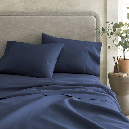 Foot-of-bed view of Whisper Organics 300 TC organic sateen flat sheet in Navy