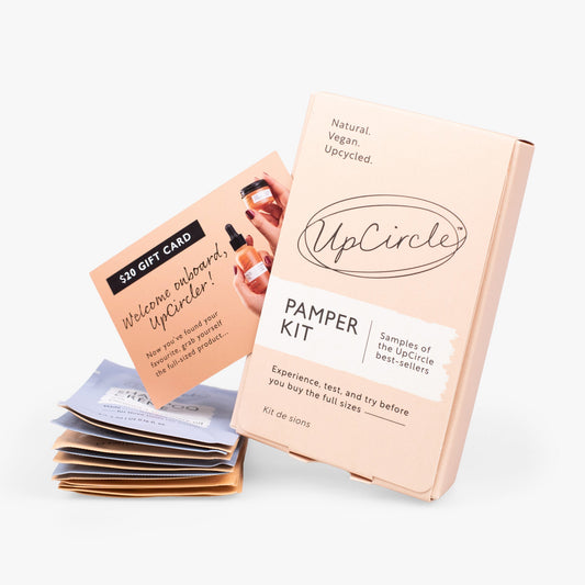UpCircle Pamper + Gift Kit closed box with a pile of sample sachets and gift card