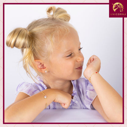 Model wearing Unicornj 14k yellow gold unicorn stud earrings with pink and white enamel, view 4