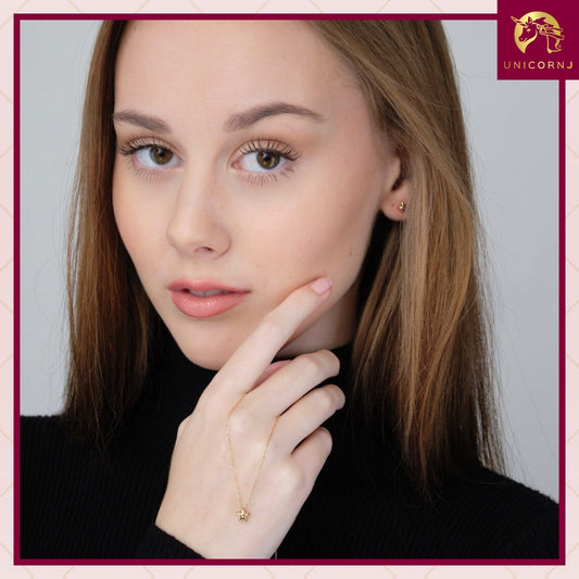Model wearing 14k yellow gold 6.5mm puff star stud earrings by Unicornj