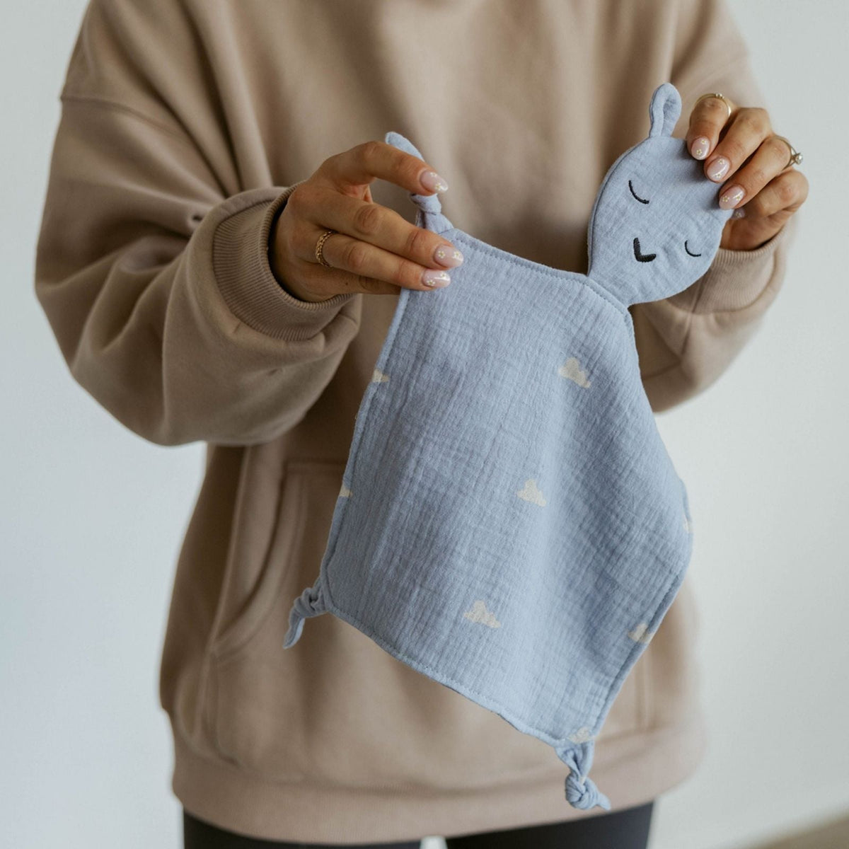 Little one holding the Parker Baby Co. Windy muslin lovey